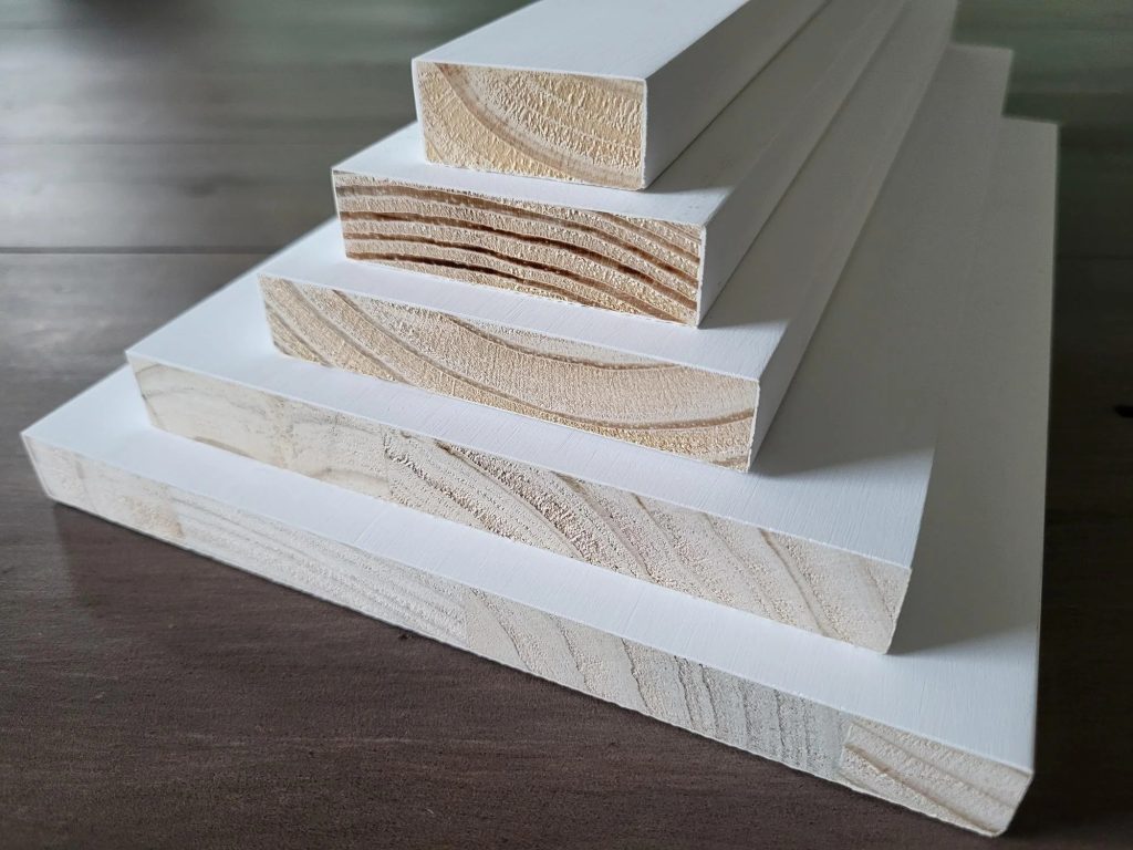Primed finger-joint pine boards stacked by size